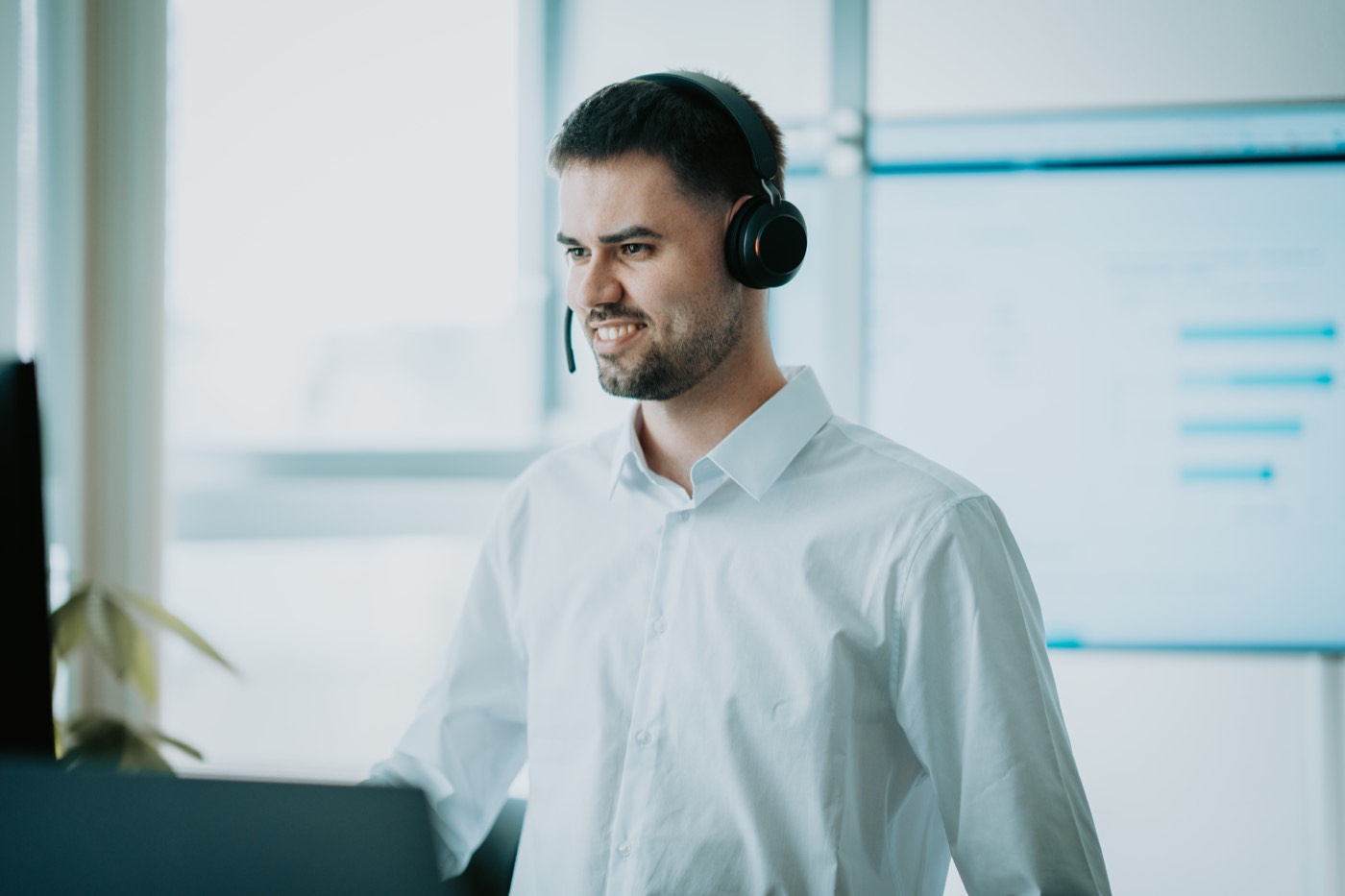 Vertriebsmitarbeiter mit Headset im Gespräch am Arbeitsplatz von Umsatz mit Autos