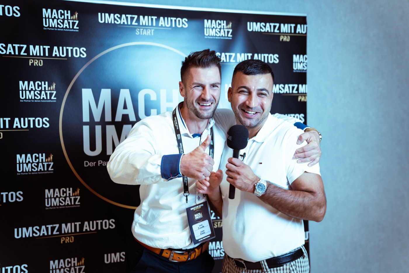 Team von Umsatz mit Autos beim Live-Event vor der Marken-Wand